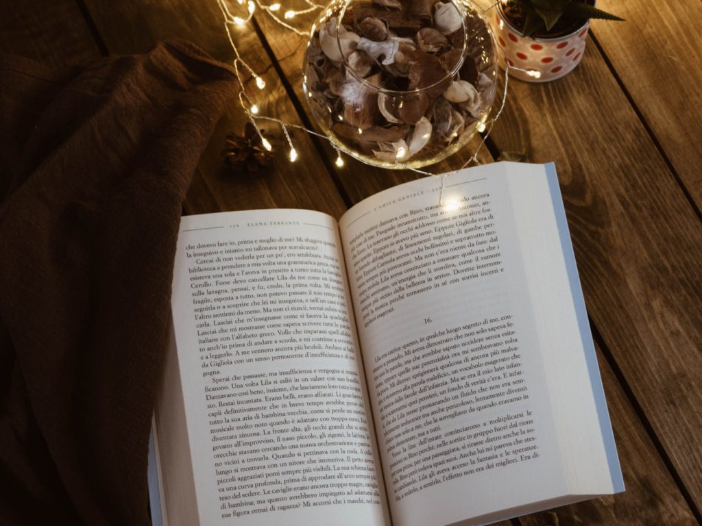 open book and fairy lights on wooden surface